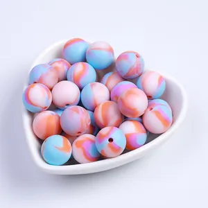 Perles en silicone aux couleurs bonbon marbrées dans une assiette blanche en cœur