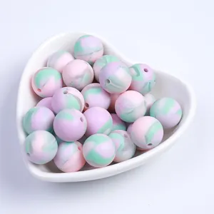 Perles en silicone marbré rose blanc et menthe dans un plat en céramique en cœur