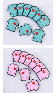 Dettaglio di ciondoli per scarpe a forma di camice medico rosa e blu con cuore per infermieri