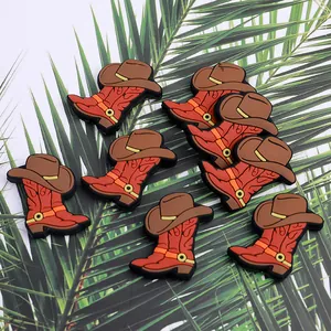 Set of 8 cowboy boot and hat shoe charms for clogs on a tropical palm leaf background