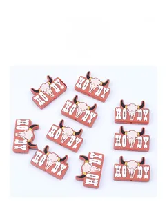 Detail of red cowboy boot silicone charms with bull skull design and Howdy lettering