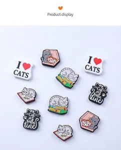 Detailed close-up of cute cartoon cat PVC charms for shoes on light blue background