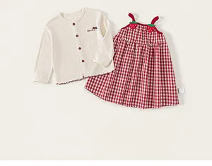 Detail of red gingham dress with 3D strawberry straps and cream knit cardigan