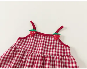 Detail of red gingham baby girl dress featuring 3D strawberry appliques on straps