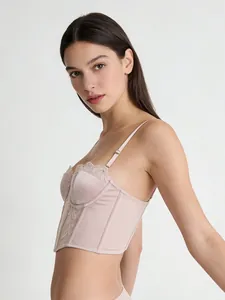 Detailed side view of champagne pink corset top featuring lace embroidery and satin texture