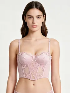 Detail of light pink lace corset featuring fishbone structure and delicate floral lace edge