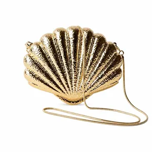 Detail of golden seashell evening bag with hammered metal texture and fine chain strap