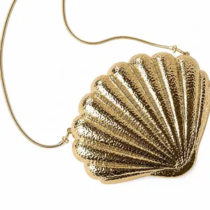 Golden shell-shaped evening clutch bag with hammered metal texture and snake chain strap