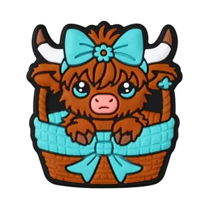 Ciondoli a forma di mucca highland in cesto marrone con fiocchi floreali azzurri