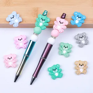 Close-up of DIY cartoon bear silicone beads on gradient and matte metal beaded pens