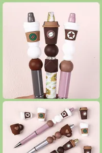 Detalle de cuentas de silicona con tema de café y bolígrafos DIY sobre fondo rosa suave