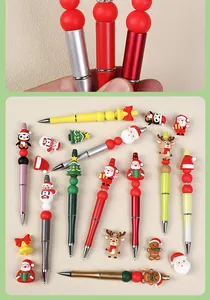 Dettaglio macro di penne natalizie con perline e figure in silicone di Babbo Natale