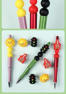 Close-up of 3D sun and school bus silicone beads on colorful beaded pens set