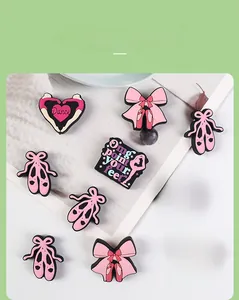 Detailed view of ballet dance themed PVC shoe charms with pink bows and heart designs