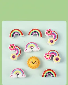 Detailed view of nine colorful 3D silicone rainbow and smiling sun charms for DIY projects