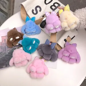 Detail of plush rabbit keychains in various colors with soft fur and metallic gold hooks