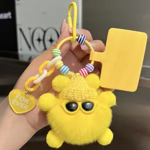Detail of yellow fluffy keychain with sunglasses, striped beads and a heart charm