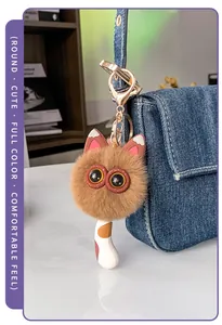 Plüsch-Katzen-Schlüsselanhänger aus Kaninchenfell-Imitat an einer blauen Jeans-Tasche