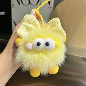 Detalle de llavero de peluche amarillo brillante con ojos grandes y correa de cuentas