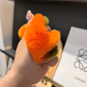 Dettaglio del portachiavi a cuore in peluche arancione con accenti verde oliva