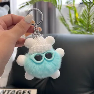 Close-up of fluffy blue rabbit fur keychain with a knit hat and stylish sunglasses