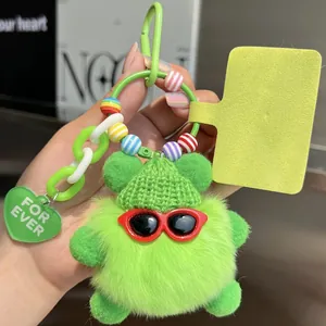 Detail of green furry monster keychain with sunglasses and colorful bead chain accessory