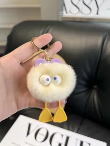 Detailed close-up of fluffy duck plush keychain with purple ears and gold metal ring