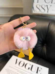 Close-up of pink faux rabbit fur duck keychain with big eyes and golden ring hook
