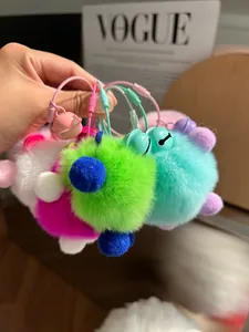 Close-up of colorful faux fur pom-pom keychains with matte metal bells in various vibrant colors
