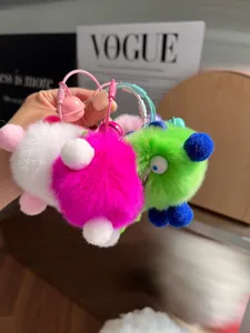 Detailed close-up of fluffy rabbit fur pompom keychains with colorful wire rings and bells