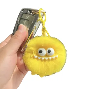 Cute yellow plush monster keychain with fuzzy fur and white teeth for bag or car keys