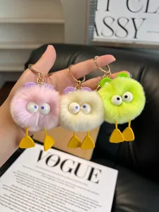 Detailed view of three colorful plush duck keychains in pink, yellow and neon green colors