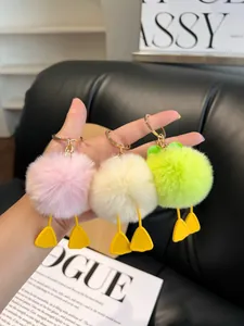 Close-up of fluffy faux fur duck paw keychains in pink, yellow, and green colors