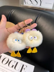 Close-up of cute plush duck keychain with fluffy faux fur and yellow webbed feet detail