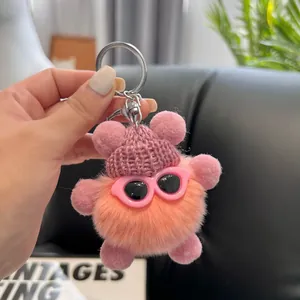 Detail of pink gradient plush keychain with mini sunglasses and knit hat on car seat