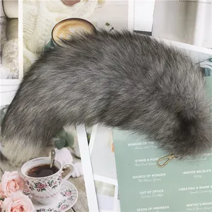 Détail d'un pendentif en queue de renard grise en fausse fourrure avec fermoir doré