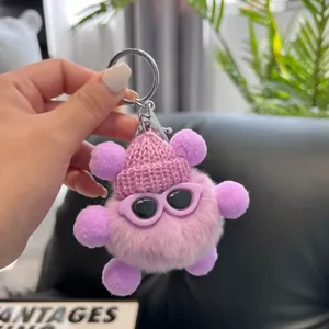 Close-up of cute purple plush coal ball keychain with a knitted hat and sunglasses