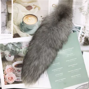 Gros plan d'un pendentif queue de renard en fausse fourrure grise longue et douce