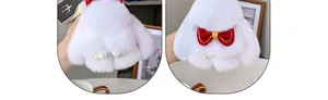Detalle del llavero de conejo de peluche blanco con lazo rojo y adornos de perlas