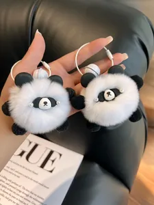 Detail of two plush panda fur ball keychains with white wire rings and metal bells