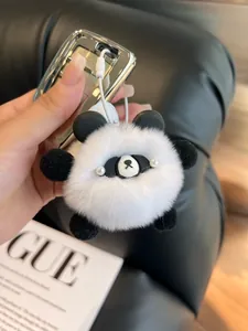 Close-up of soft panda plush keychain with fluffy fur texture on car key fob