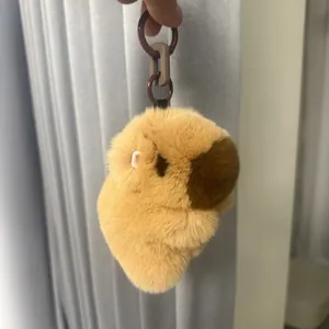 Detailopname van een capibara pluche sleutelhanger met zacht bruin bont en plastic ketting