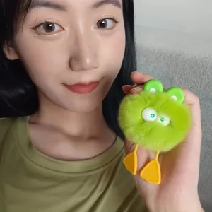 Funny green plush duck keychain ball with large eyes and orange feet held by hand