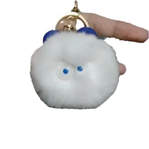 Fluffy white monster plush keychain with blue ears and gold metal keyring clip