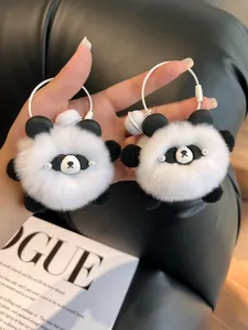 Close-up of fluffy panda plush keychains with soft faux fur and white bells