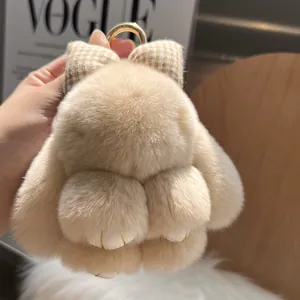 Detail of soft beige plush bunny keychain with a plaid bow and gold metal ring
