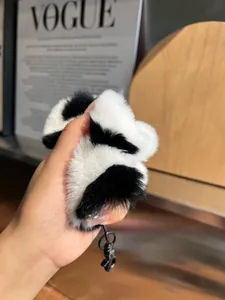 Detailed view of soft black and white plush charm with durable black metal buckle