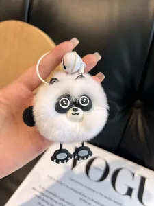 Detail of soft real rabbit fur panda keychain with fluffy white fur and a small bell
