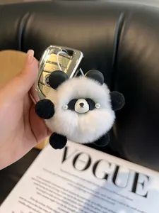Detailed plush texture of a panda keychain featuring imitation pearl eyes on car keys