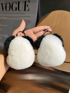 Detailed close-up of pair of panda fluffy fur keychains with black metal clips